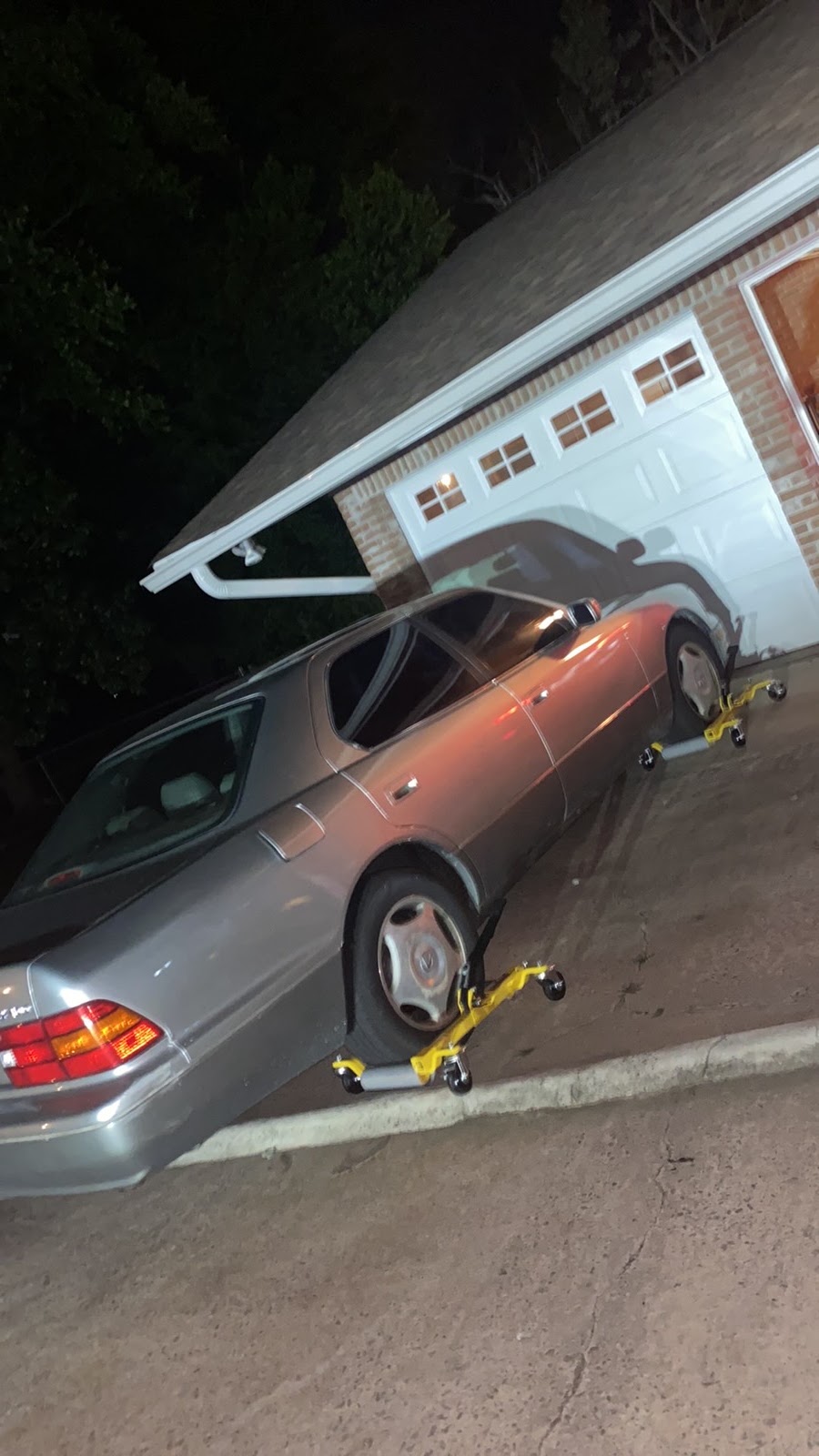A car being recovered at night with wheel dollies